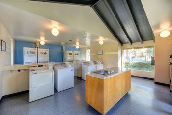 Community laundry room with washers, dryers, sink and large window